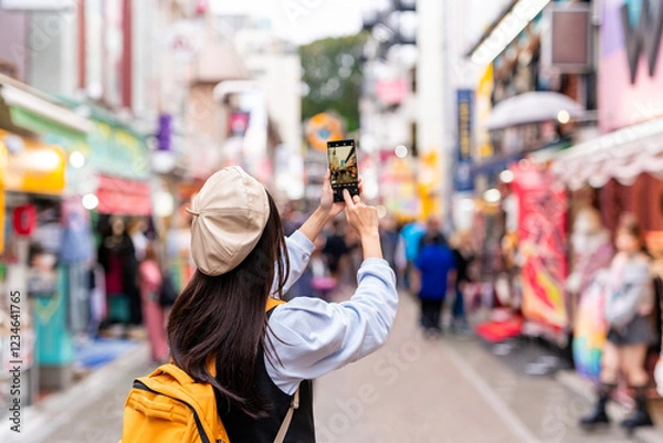 Obraz Young woman tourist walking on the Takeshita street in Harajuku the center of teenage fashion and cosplay culture in Tokyo
