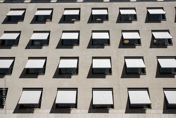 Fototapeta Boring gray facade of office building in Stockholm, Sweden. Abstract photo of windows on a completely monotone grey wall. 