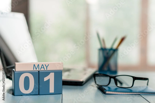 Fototapeta May 1st. Day 1 of month, calendar on business office background, workplace with laptop and glasses. Spring time, empty space for text