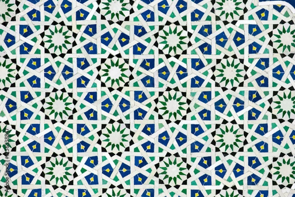 Fototapeta A detailed Islamic geometric mosaic featuring vibrant colors and symmetrical patterns. The design showcases traditional arabesque motifs with star shapes and interwoven lines