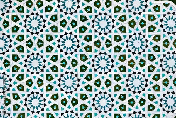 Fototapeta A detailed Islamic geometric mosaic featuring vibrant colors and symmetrical patterns. The design showcases traditional arabesque motifs with star shapes and interwoven lines