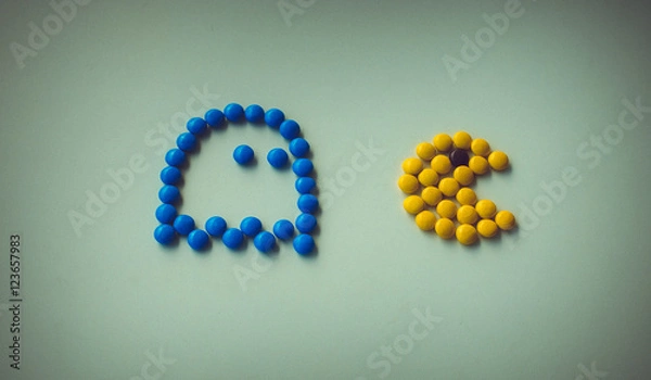 Fototapeta Color Candy pac man with ghost chasing it on white background arranged in pac-man style. Funny game with food,  closeup. Halloween holidays
