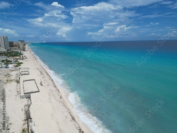 Obraz Aerial Top view of a transparent blue sea with beautiful waves at sunny day in summer. Tropical landscape from the air of ocean with azure water, sandy bottom at sunset. Cancun, Mexico.