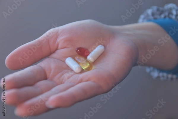 Obraz Hand taking vitamins, omega 3, magnesium