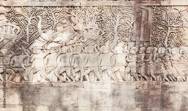 Fototapeta Bas-reliefs sandstone shows a Khmer army on the march in Angkor Thom. Siem Reap. Cambodia