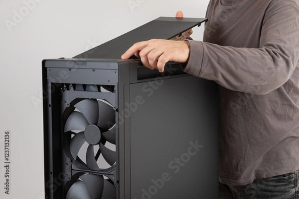 Fototapeta Man installing  top panel with dust filter from  PC case, empty big tower, chassis. Under top panel is place for 420 mm radiator for AIO cooling