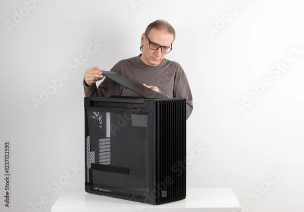 Fototapeta Man installing  top panel with dust filter to  PC case, empty big tower, chassis. Under top panel is place for 420 mm radiator for AIO cooling