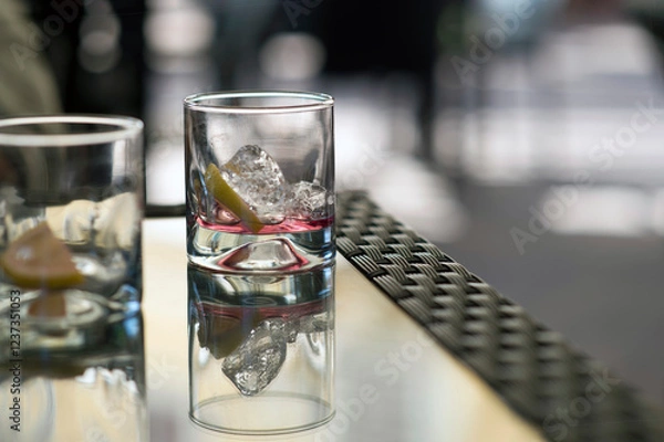 Obraz empty glasses on a bar table with ice cubes