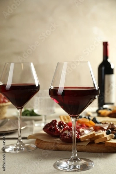 Fototapeta Red wine and different snacks served on light grey table