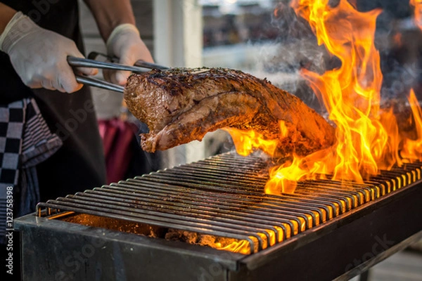 Obraz Grilling entrecote on a barbecue with fire 