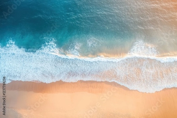 Fototapeta Aerial view of a tranquil beach showcasing gentle waves lapping against a golden shore, creating a serene coastal scene.