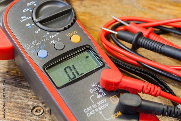 Obraz Clamp multimeter with accessories on a table in a workshop