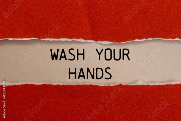 Fototapeta Wash your hands message written on ripped torn red paper with beige background. Conceptual wash your hands symbol. Copy space.