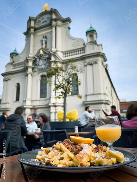 Fototapeta Traditional emperor’s mess  scrambled pancake with views of Holy Spirit Church on background in Munich. European tourism, gastronomy tour concepts