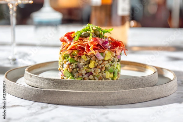Fototapeta Superfood buckwheat tartare with avocado, capers and red onion, topped with serrano jamon slices