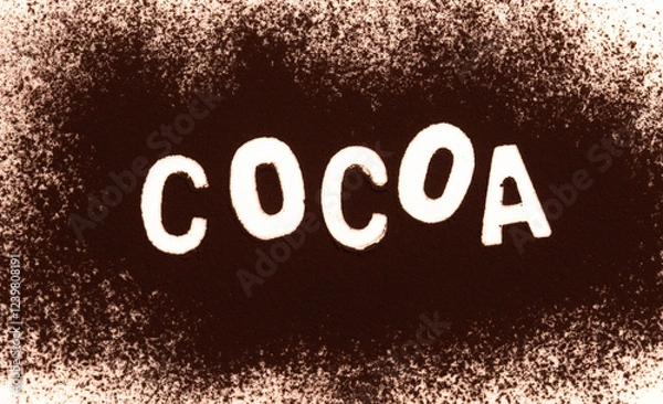 Fototapeta Cocoa powder spilled on white to form a word.
