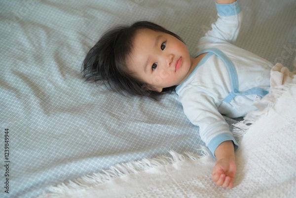 Obraz Cute baby is resting on a comfortable bed.