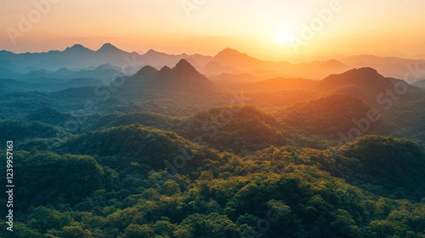 Fototapeta A serene, breathtaking sunset casts warm hues over majestic mountain ranges, symbolizing peace, reflection, and the fleeting beauty of nature. Modern blurred space adds a contemporary touch.

