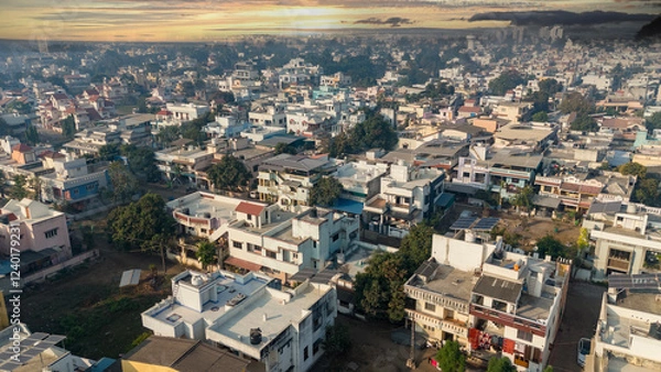 Fototapeta Aerial view of city with dramatic sky at evening time.