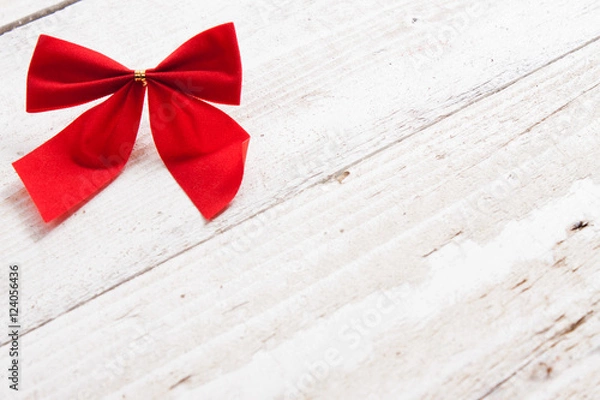 Obraz Decorative red ribbon and bow on a background of white painted r