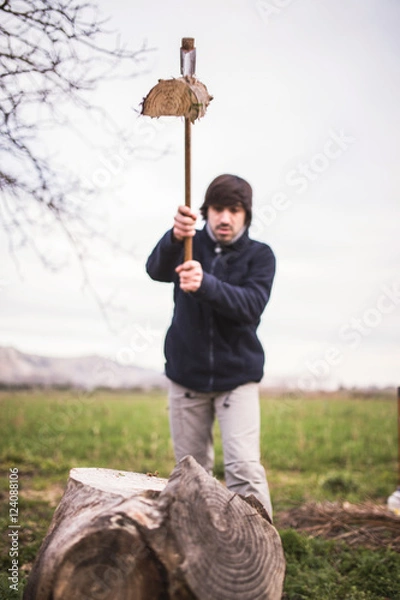 Obraz man chopping wood with an ax