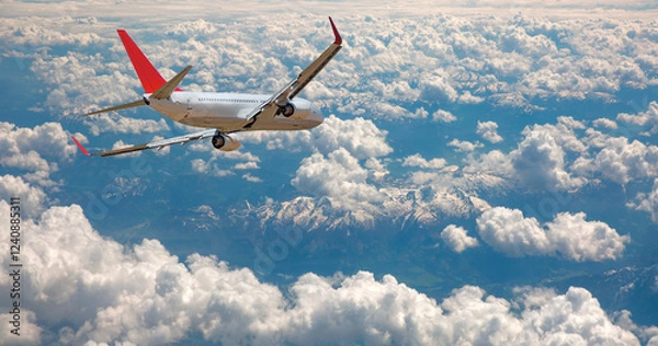 Obraz An airplane flying over a taurus mountain range, with snow-capped peaks visible below