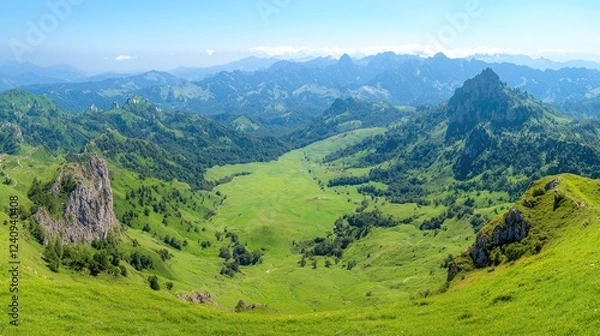 Obraz Panoramic view of lush green valley, mountains, and blue sky. Ideal for travel brochures