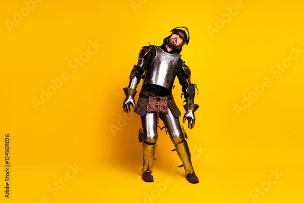 Fototapeta Portrait of a young man dressed as a medieval knight in armor against a vibrant yellow background