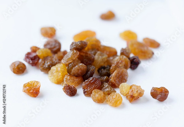 Obraz A bunch of tasty and appetizing raisins of yellow and brown color, on a light background. Natural and healthy sweets