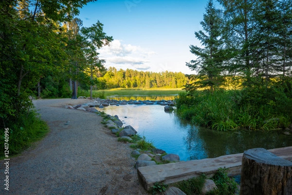 Obraz Gravel walkway along the Mississippi River at its source, where the water flows out of Lake Itasca in Minnesota over a small rock dam.