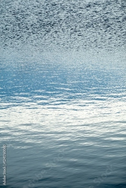 Fototapeta Abstract azure water surface with mild waves, vertical image, reflection of sky