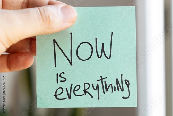 Fototapeta Sticky Notes with 'Now is Everything' on Colored Paper