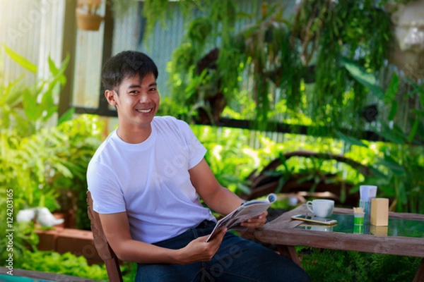 Fototapeta uśmiechnięty azjatycki mężczyzna dorywczo czytanie magazynu