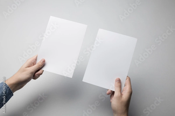 Fototapeta Hand holding Blank A5 Flyer / Invitation Mock-up.