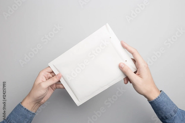 Obraz Hand holding blank padded envelope