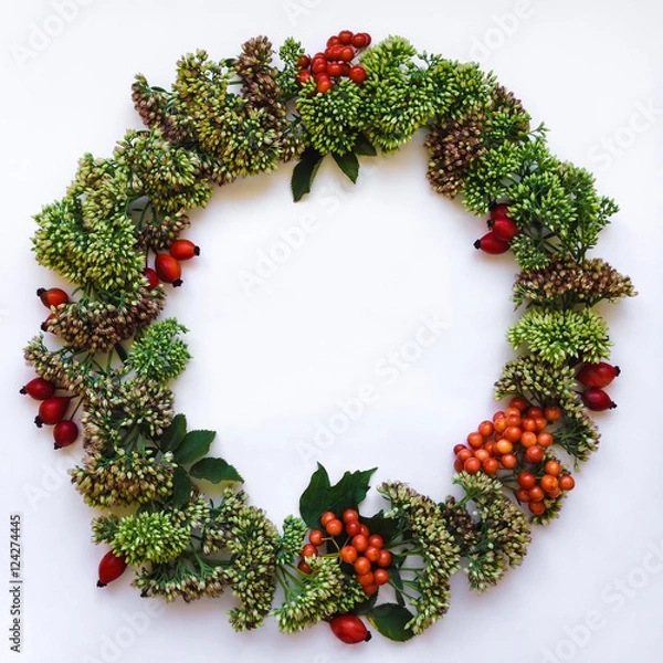 Fototapeta Green floral round wreath frame on white background. Flat lay, top view, view from above. Autumn or winter decoration