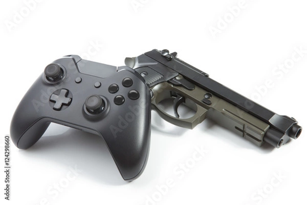 Fototapeta Game controller and a real handgun near it - studio shot. Virtual and real life concept