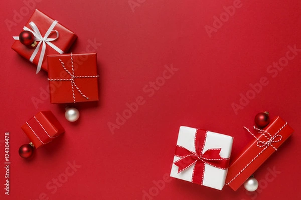 Fototapeta Christmas gifts presents on red background. Simple, classic, red and white wrapped gift boxes with ribbon bows and festive holiday decorations.