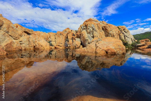 Fototapeta Tranquil rock formations reflecting in a serene water pool during a bright day in South Africa