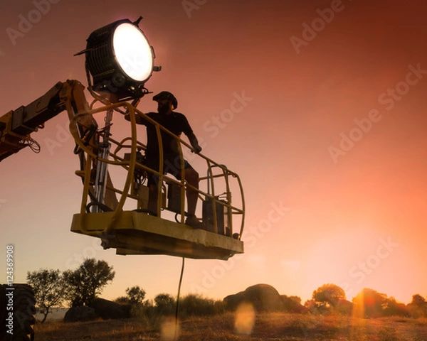 Fototapeta Lighting technician working on a shoot