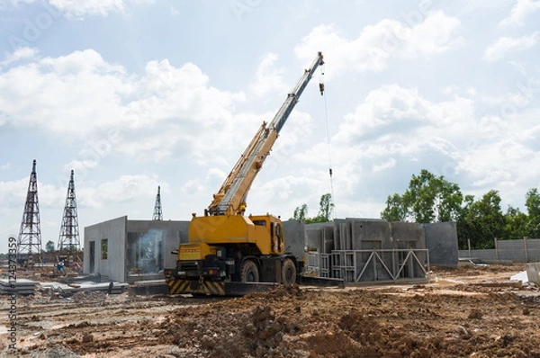 Fototapeta Construction site crane is used to placing precast concrete pane