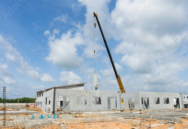 Fototapeta Construction site crane is used to placing precast concrete pane