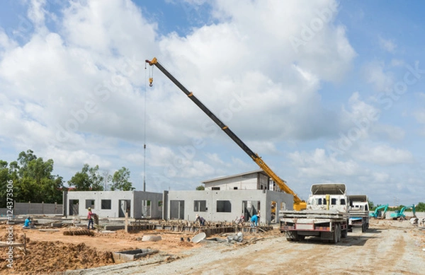 Fototapeta Construction site crane is used to placing precast concrete pane