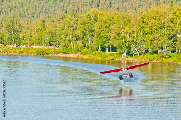 Obraz Alaskan float plane takes off from a river.