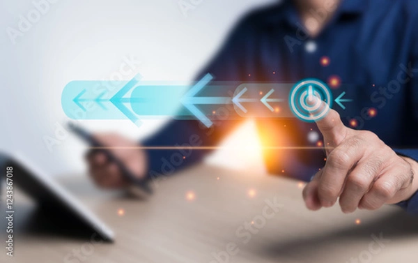 Fototapeta On off button, switch, and arrow virtual hologram icon drive the operation of the cutting-edge technology system and add orange light to the image. The businessman points to the start button.