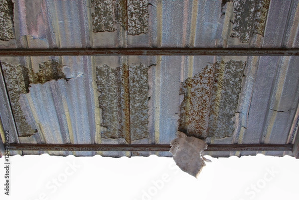 Fototapeta Close-up of a deteriorated corrugated metal roof, showing visible rust, peeling paint, and weathered surface.