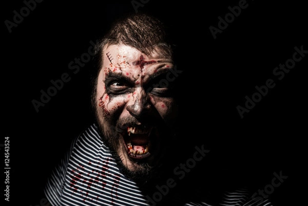 Fototapeta Vampire halloween man. Portrait of blood thirsty vampire man with blood dripping fangs - closeup.