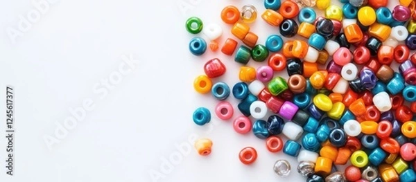 Fototapeta Colorful assortment of vibrant handmade beads scattered on the left side of a clean white surface showcasing the art of DIY jewelry making