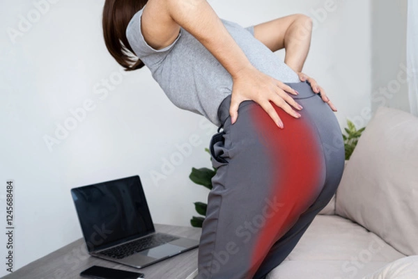 Obraz Woman experiencing sciatic nerve pain from buttock to leg due to poor posture while working at computer