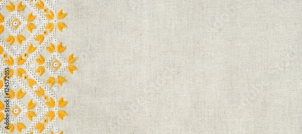 Fototapeta Embroidery design by yellow and white cotton threads on flax. Background with embroidery for banner.